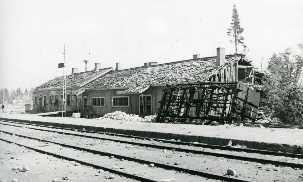 Rautatieasema taustalla, rataa edustalla. Asema kärsinyt vaurioita.