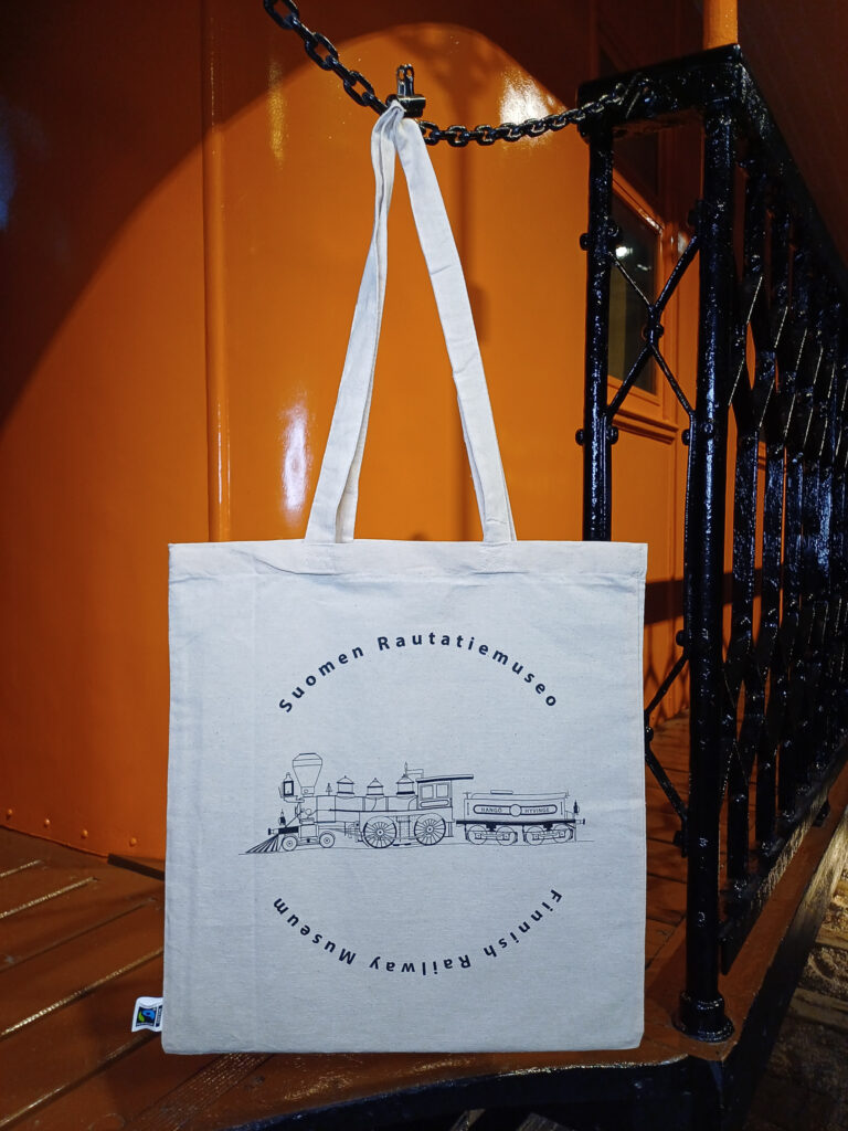 Puuvillakassi veturinkuvalla roikkuu junanvaunun kyljessä.