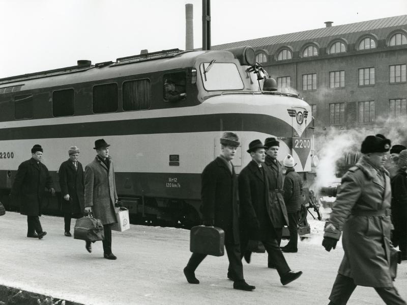 Veturi ja matkustajia rautatieasemalla.