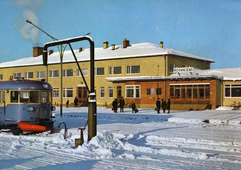 Juna ja rautatieasema talvisessa maisemassa.